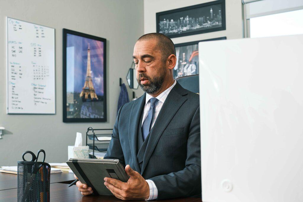 Vertices accounting owner reviewing a tablet at a wooden desk
