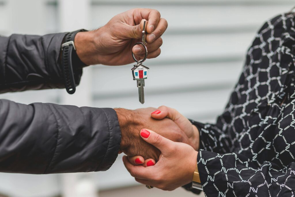 Two adults shaking hands and holding new house keys