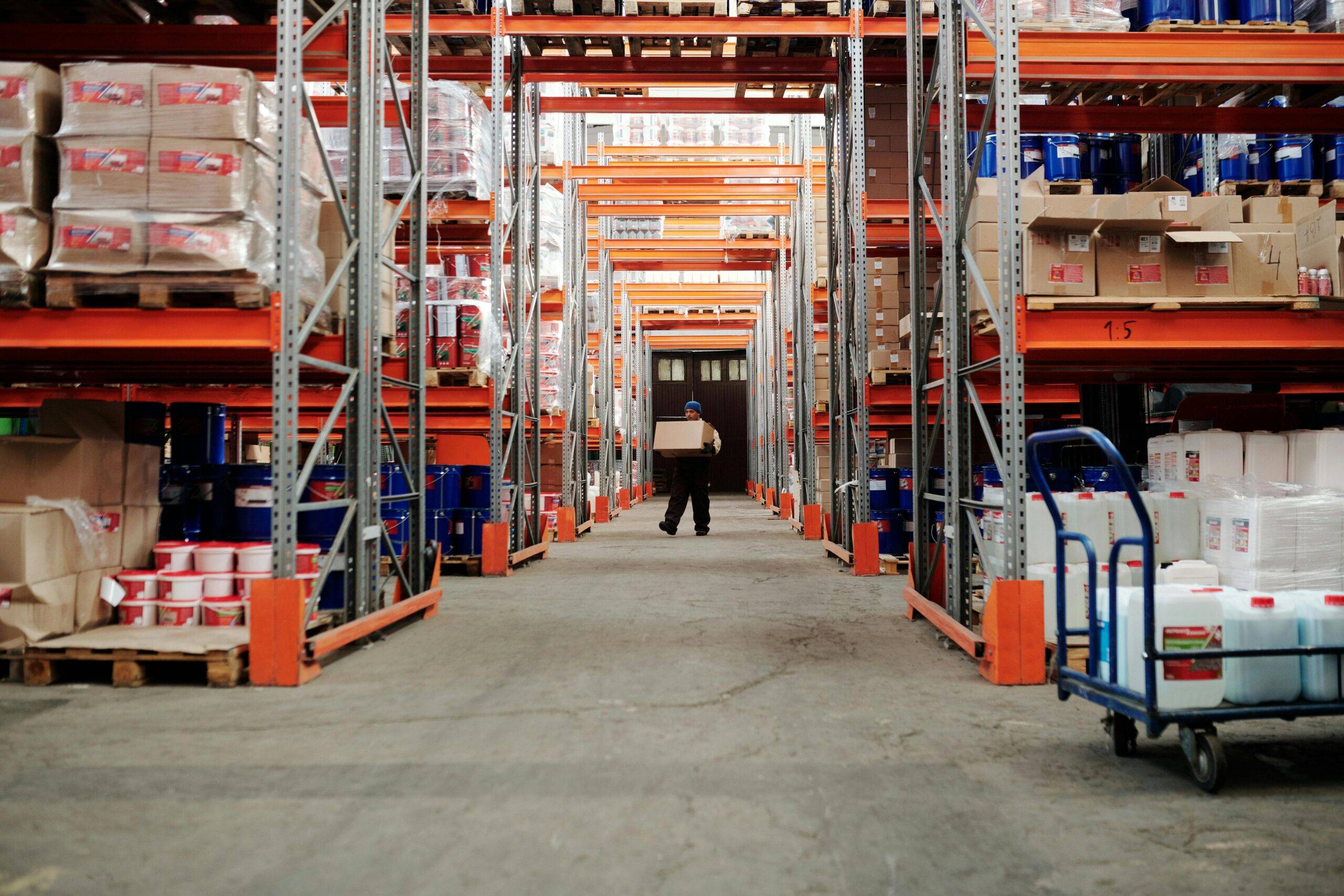 A warehouse worker carrying a cardboard box